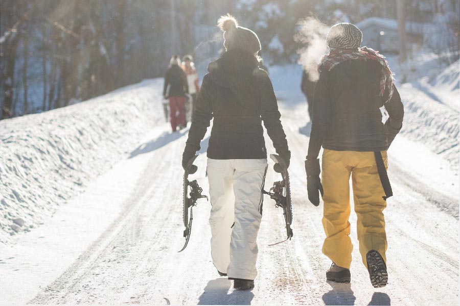 Mehrere Personen wandern im Schnee im Sonnenschein